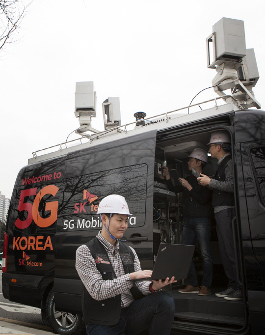 SK텔레콤이 '이동형 5세대이동통신(5G) 인프라'에 자사의 가상화 플랫폼인 티-마노(T-MANO)를 연동해 재해 복구  및 대형 행사 현장에서 '맞춤형 5G' 서비스를 제공한다. SK텔레콤 직원들이 성남시 분당구청 잔디광장에 '이동형 5G 인프라'를 설치하고,  5G 성능을 최적화하고 있다.  SK텔레콤 제공